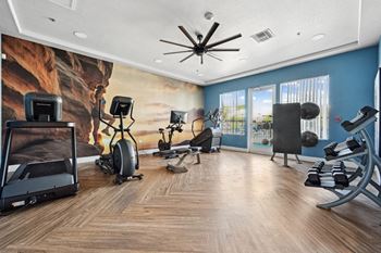 A home gym with a variety of equipment including a treadmill, stationary bike, and weight bench.
